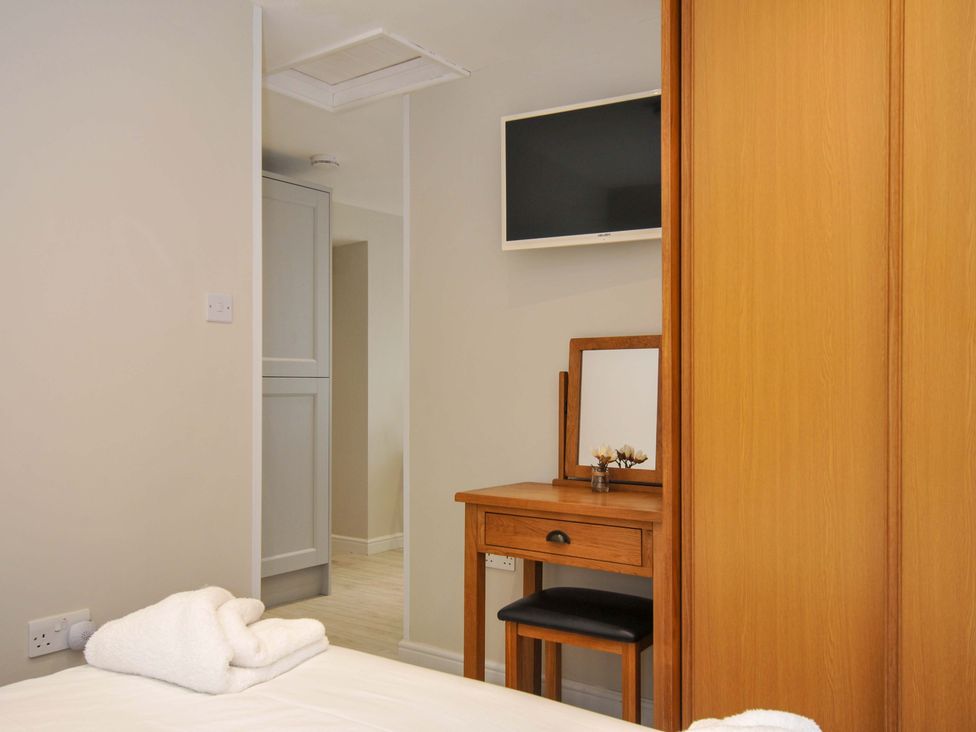 A bedroom with a bed and a desk at Evelyn in Looe