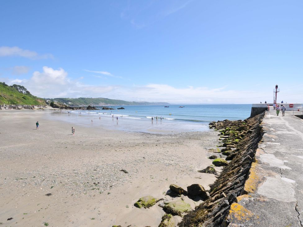 A beach with people and water at Evelyn in Looe