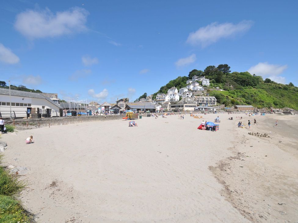 A beach scene with people and buildings at Evelyn in Looe