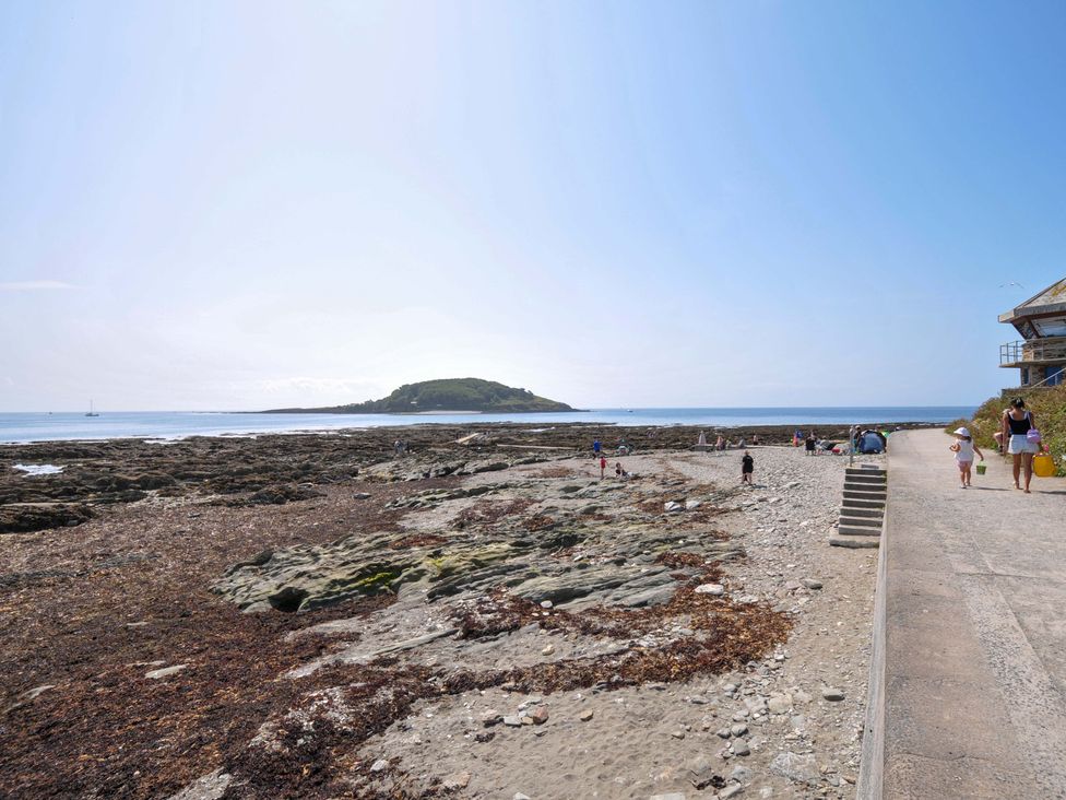 A beach with rocks and people at Evelyn in Looe