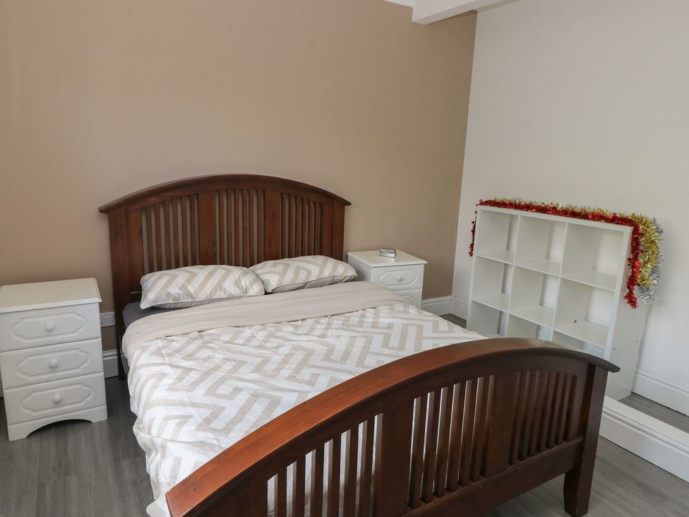 A bedroom with a bed and nightstand at Maes Hyfryd in Clynderwen