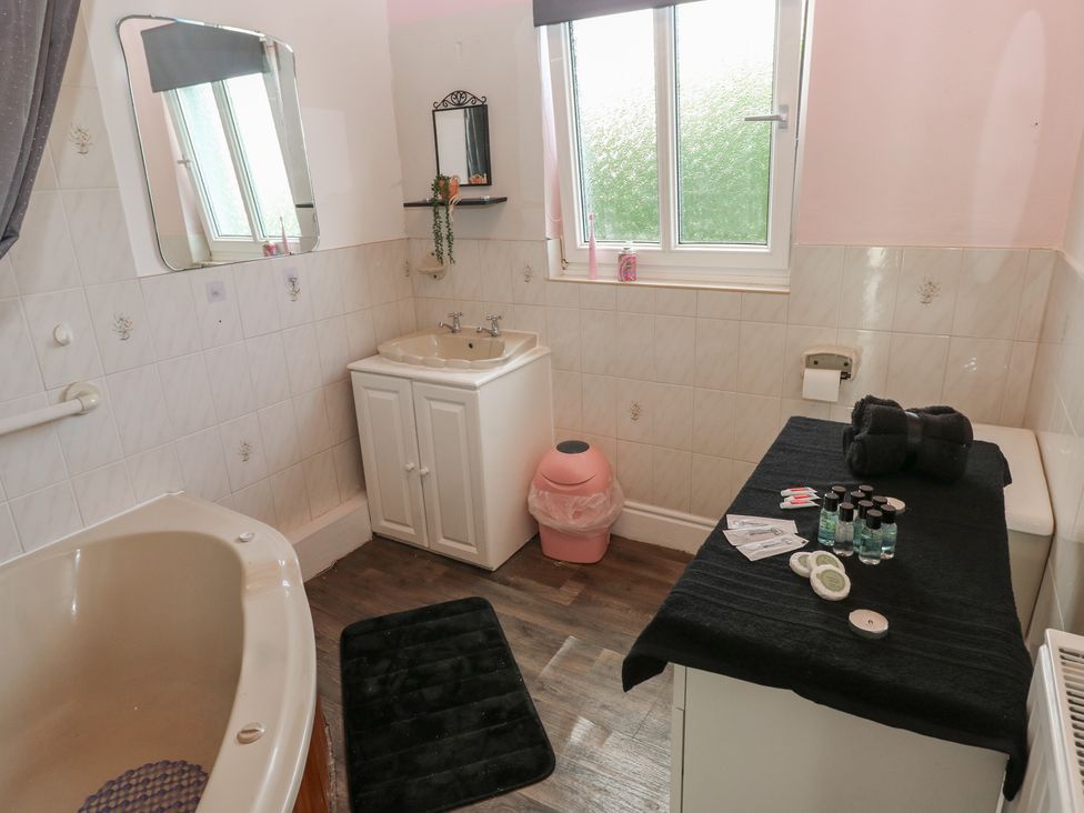 A bathroom with a bathtub and sink at Maes Hyfryd in Clynderwen