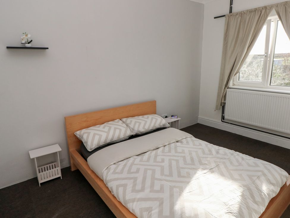 A bedroom with a bed and nightstand at Maes Hyfryd in Clynderwen