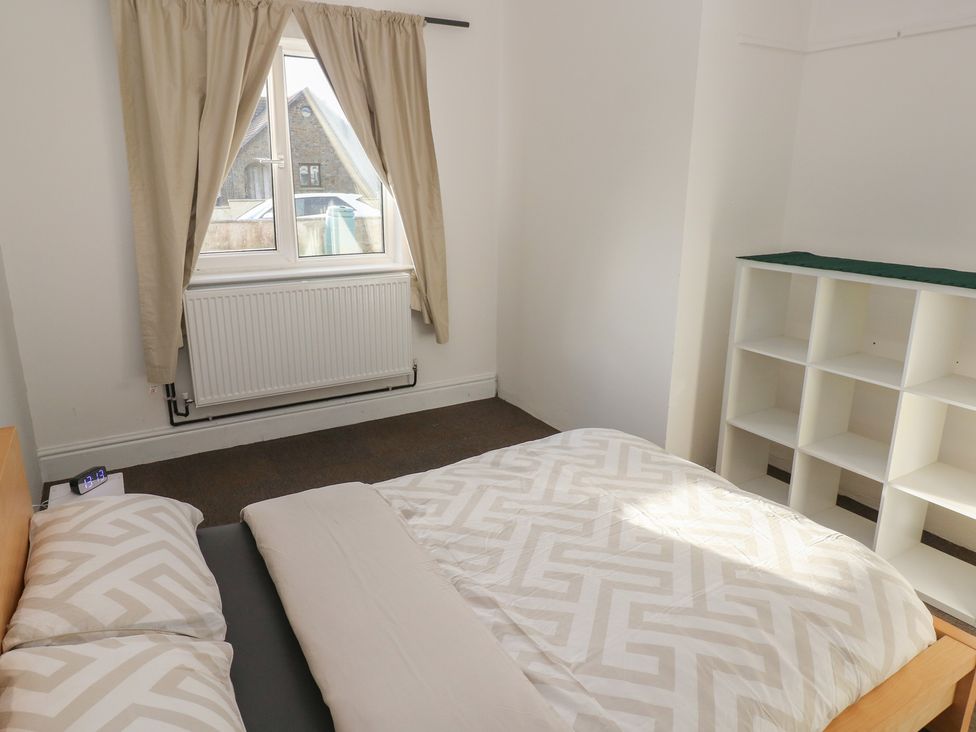 A bedroom with a bed and shelf at Maes Hyfryd in Clynderwen