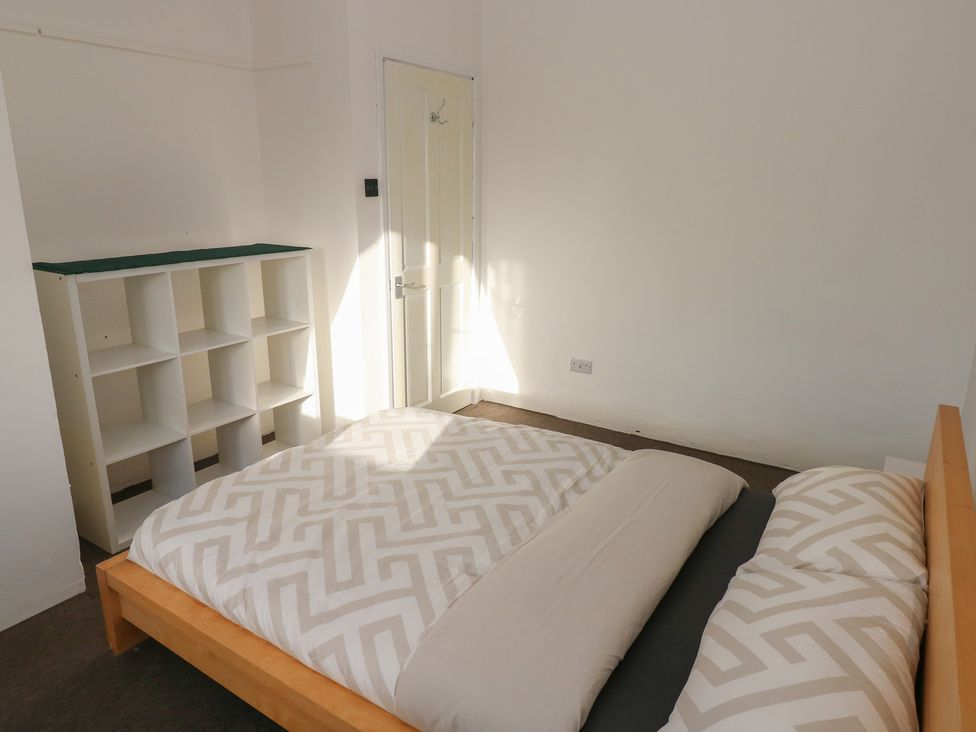 A bedroom with a bed and a shelf at Maes Hyfryd in Clynderwen