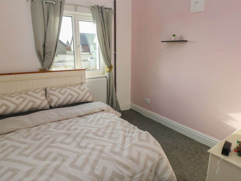 A bedroom with a bed and window at Maes Hyfryd in Clynderwen