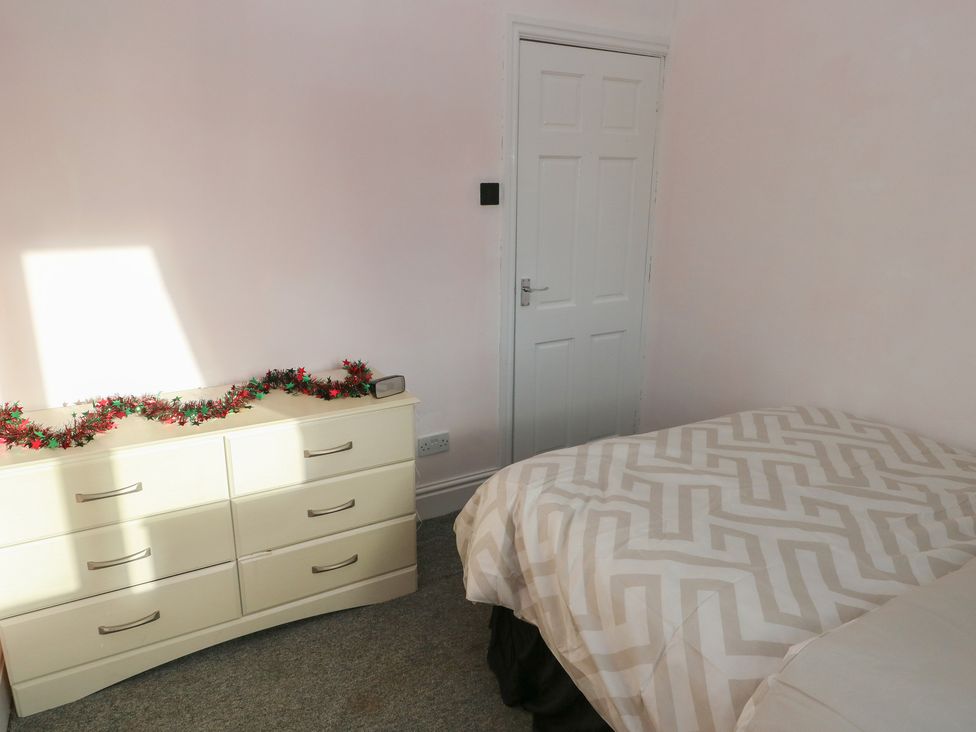A bedroom with a bed and dresser at Maes Hyfryd in Clynderwen