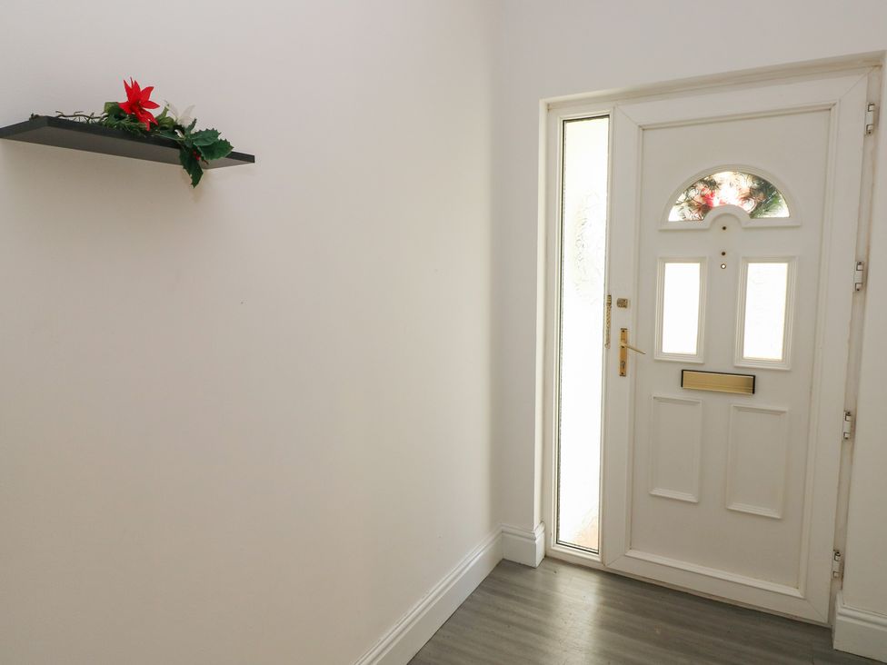 A hallway with a door and a shelf at Maes Hyfryd in Clynderwen