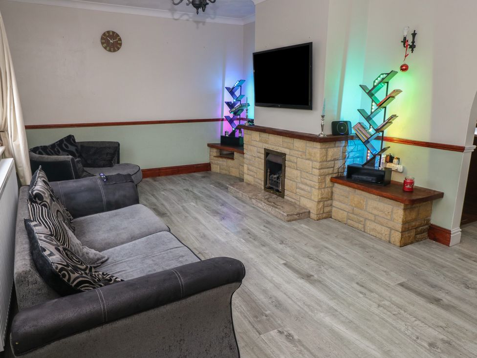 A living room with a sofa and television at Maes Hyfryd in Clynderwen