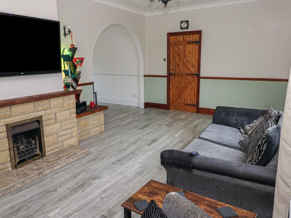 A living room with a TV and fireplace at Maes Hyfryd in Clynderwen