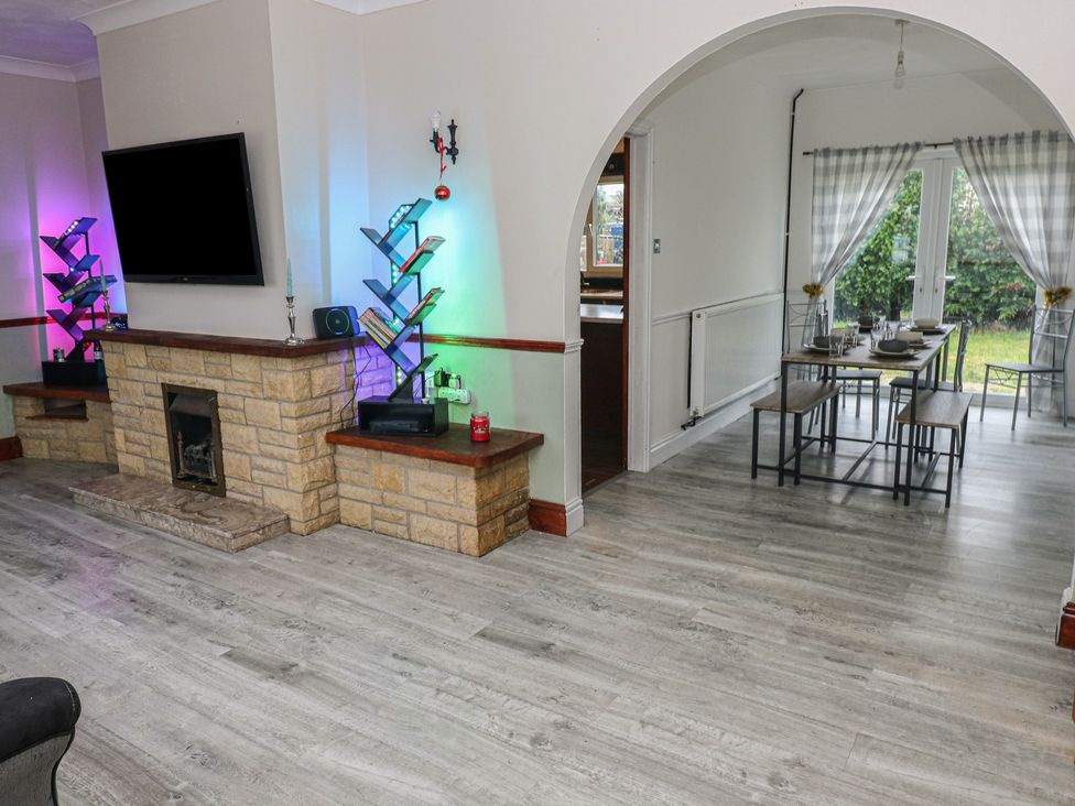 A living room with a television and a fireplace at Maes Hyfryd in Clynderwen