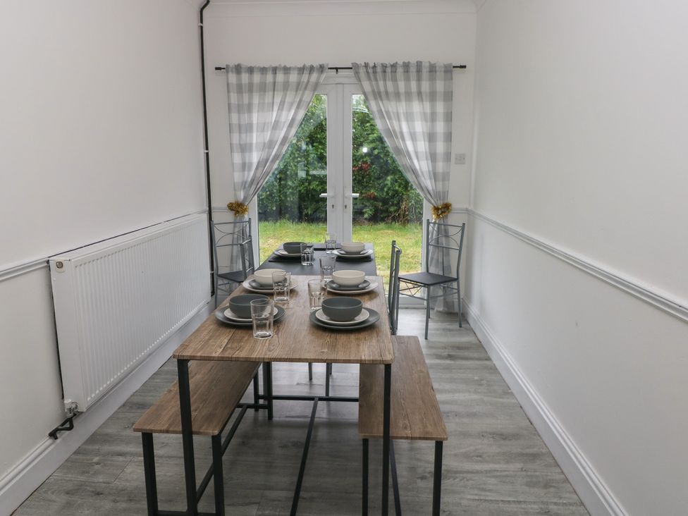 A dining room with a table set for meals at Maes Hyfryd in Clynderwen