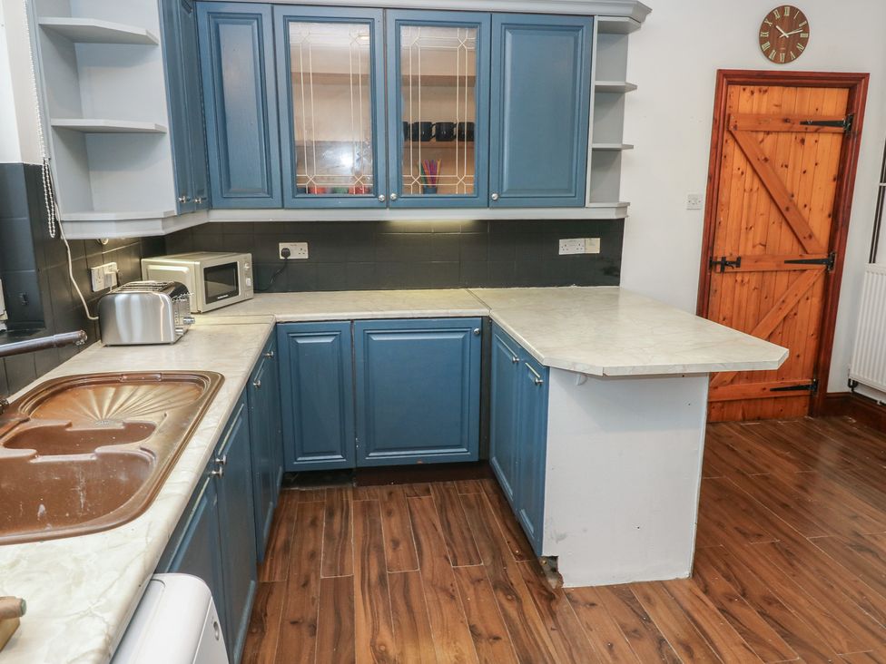 A kitchen with a sink and appliances at Maes Hyfryd in Clynderwen