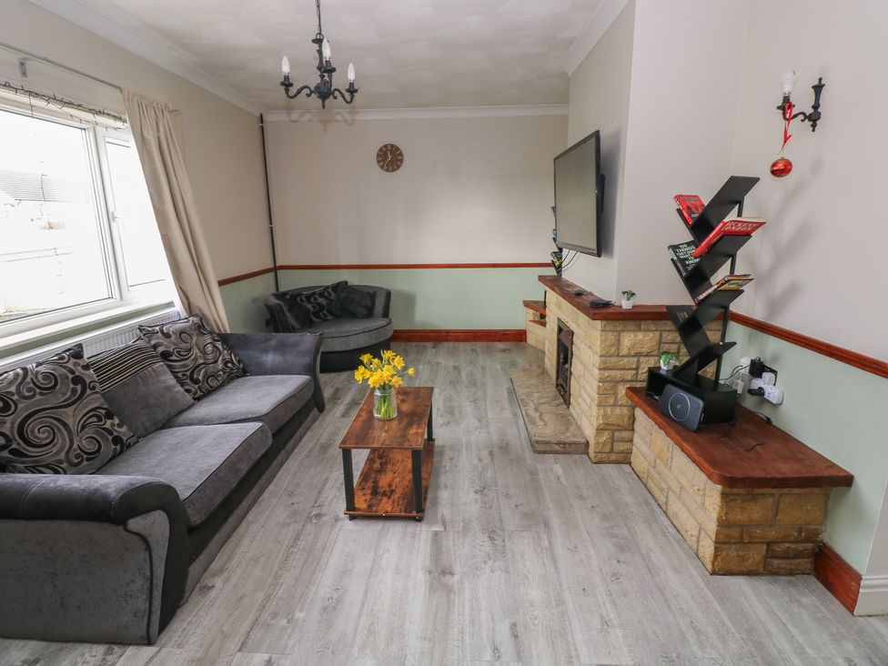A living room with a sofa and a coffee table at Maes Hyfryd in Efailwen near Maenclochog