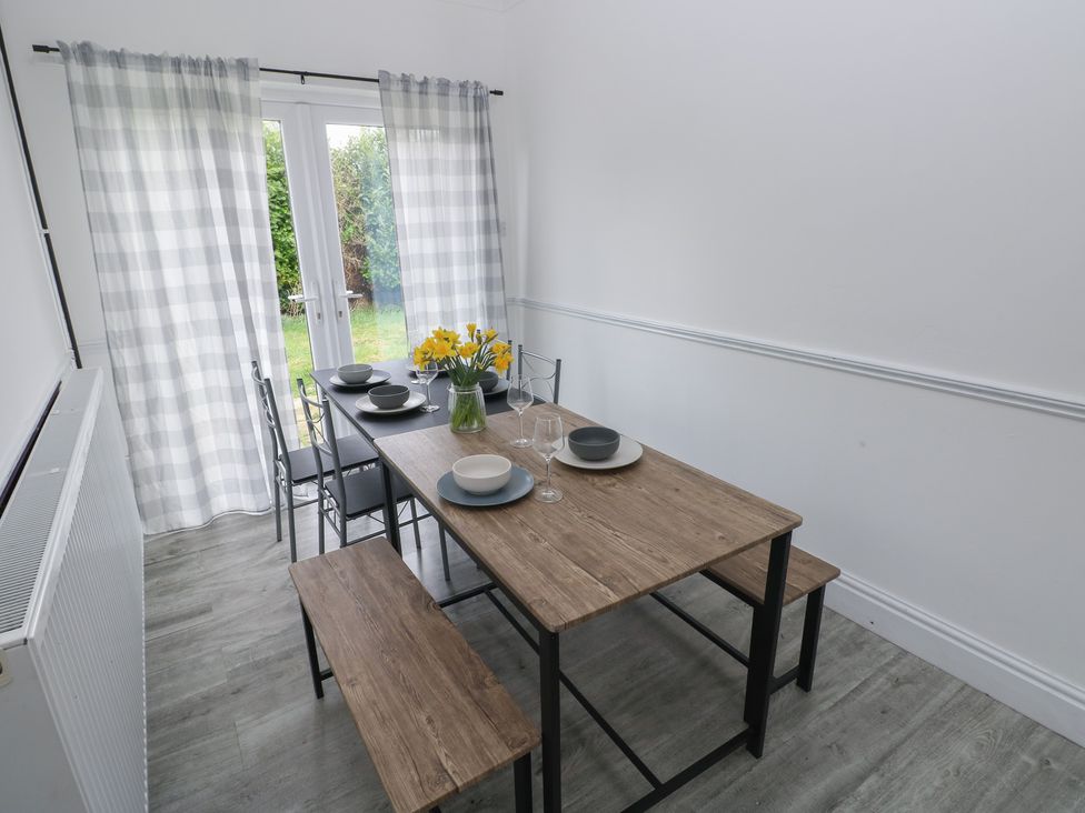 A dining room with a table set for meals at Maes Hyfryd, Efailwen near Maenclochog