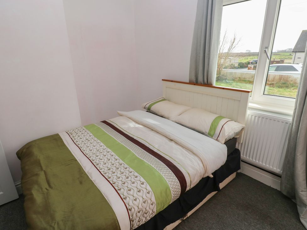 A bedroom with a bed and window at Maes Hyfryd, Efailwen near Maenclochog