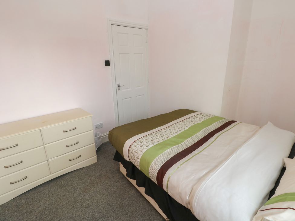 A bedroom with a bed and a dresser at Maes Hyfryd in Efailwen near Maenclochog
