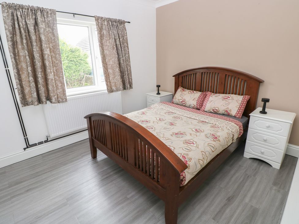 A bedroom with a bed and bedside tables at Maes Hyfryd Efailwen near Maenclochog