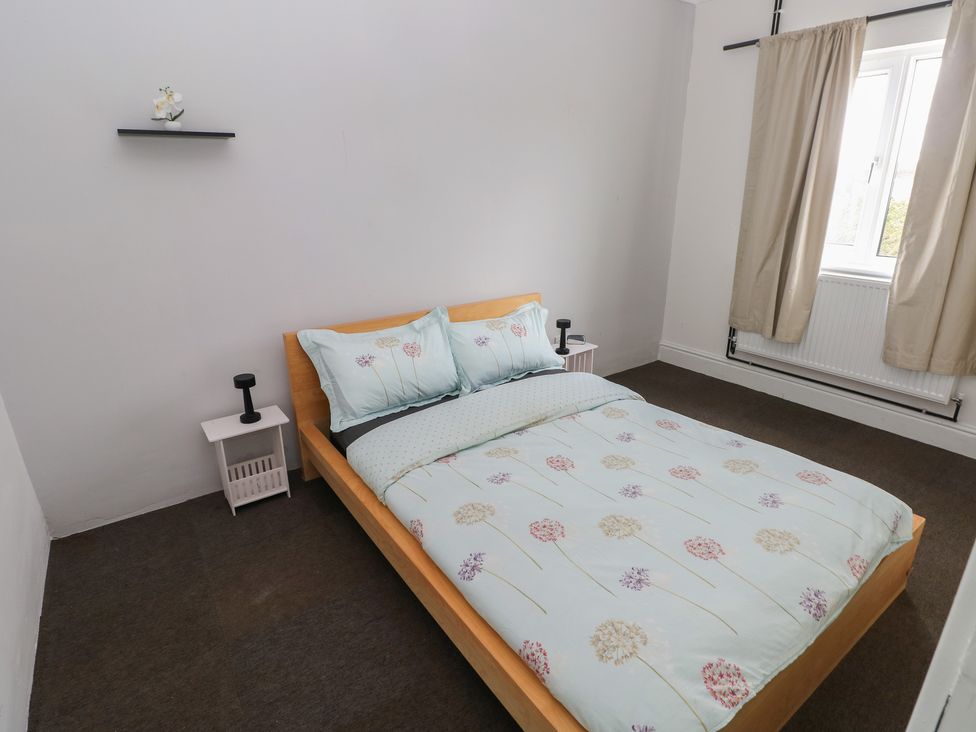 A bedroom with a bed and side tables at Maes Hyfryd Efailwen near Maenclochog