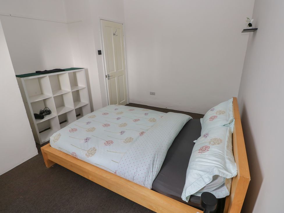 A bedroom with a bed and shelf at Maes Hyfryd Efailwen near Maenclochog