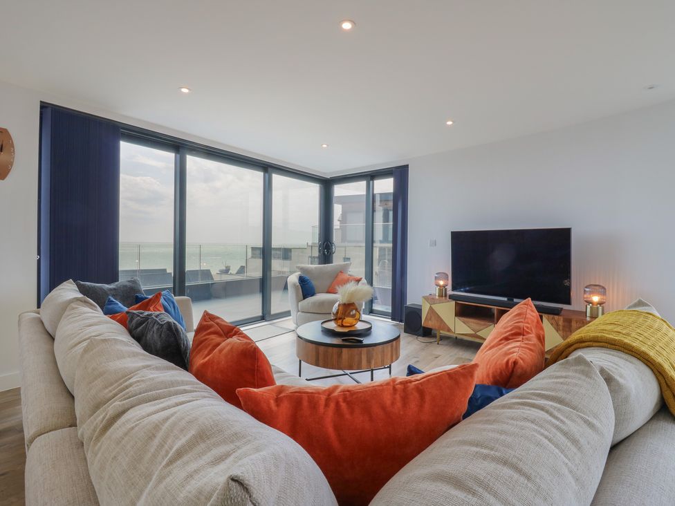 A living room with a sofa, television, and coffee table at Flat 4 Hythe