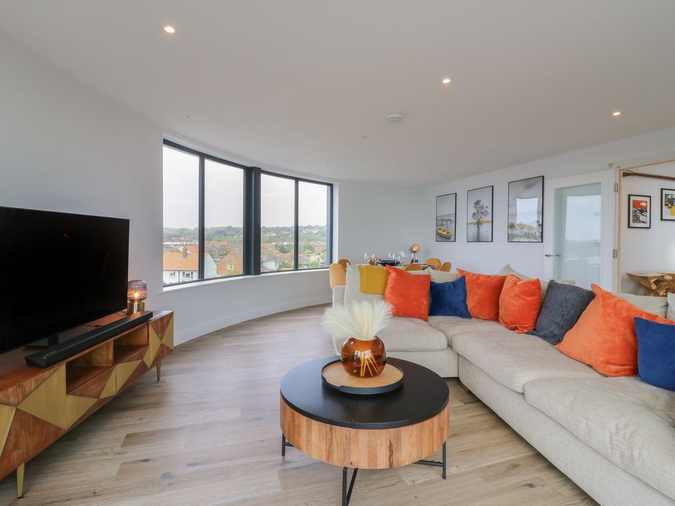 A living room with a sofa and television at Flat 4 Hythe