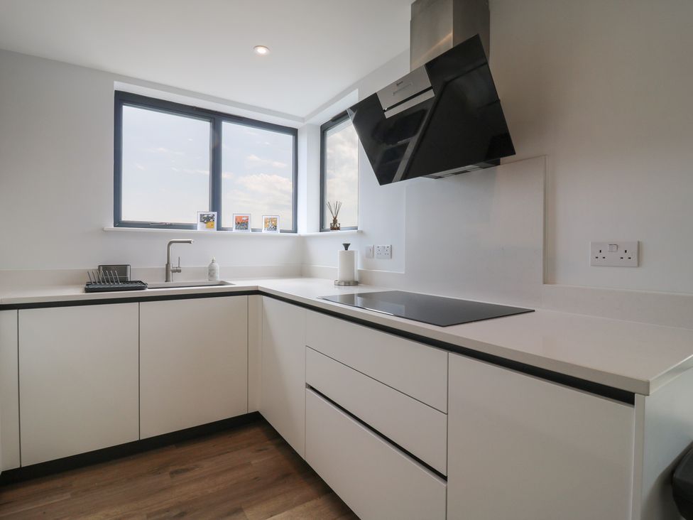 A kitchen with cabinets, countertop, sink and stove at Flat 4 in Hythe