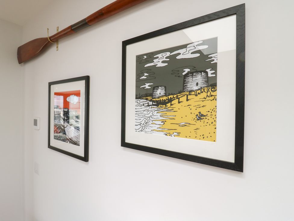 A wall with framed artwork and an oar at Flat 4 in Hythe
