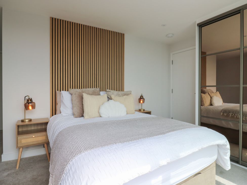 A bedroom with a bed, bedside table, and lamp at Flat 4 in Hythe