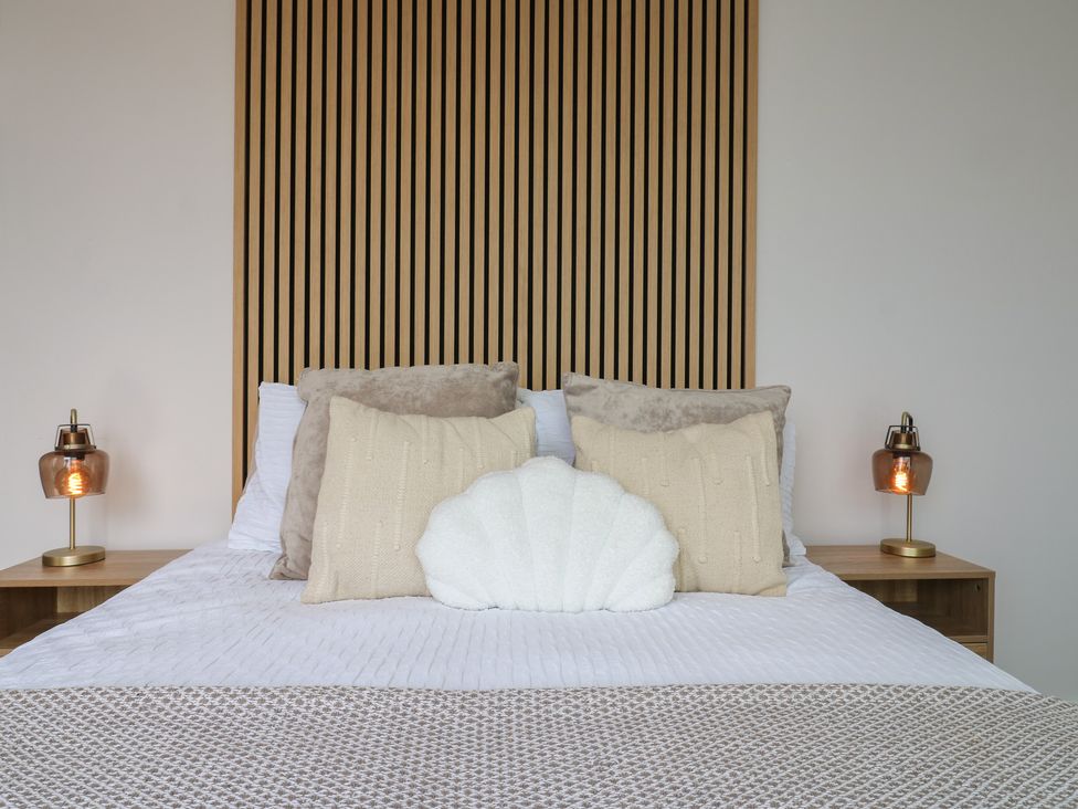 A bedroom with a bed and decorative pillows at Flat 4 in Hythe