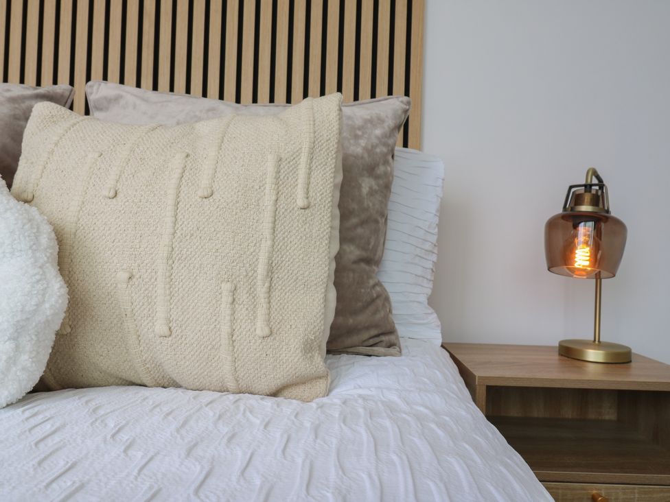 A bedroom with a bed and a lamp on a nightstand at Flat 4 in Hythe