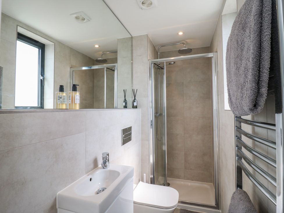 A bathroom with a sink, toilet, and shower at Flat 4 in Hythe