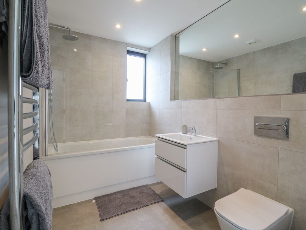 A bathroom with a bathtub, shower, sink, and toilet at Flat 4 in Hythe