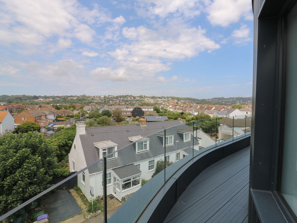 A balcony view overlooking residential buildings and greenery at Flat 4 Hythe
