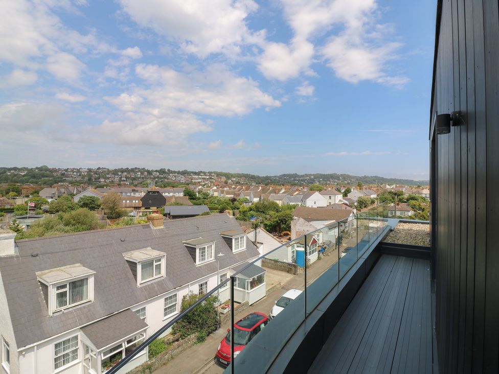 A view from a balcony overlooking rooftops and hills at Flat 4 in Hythe