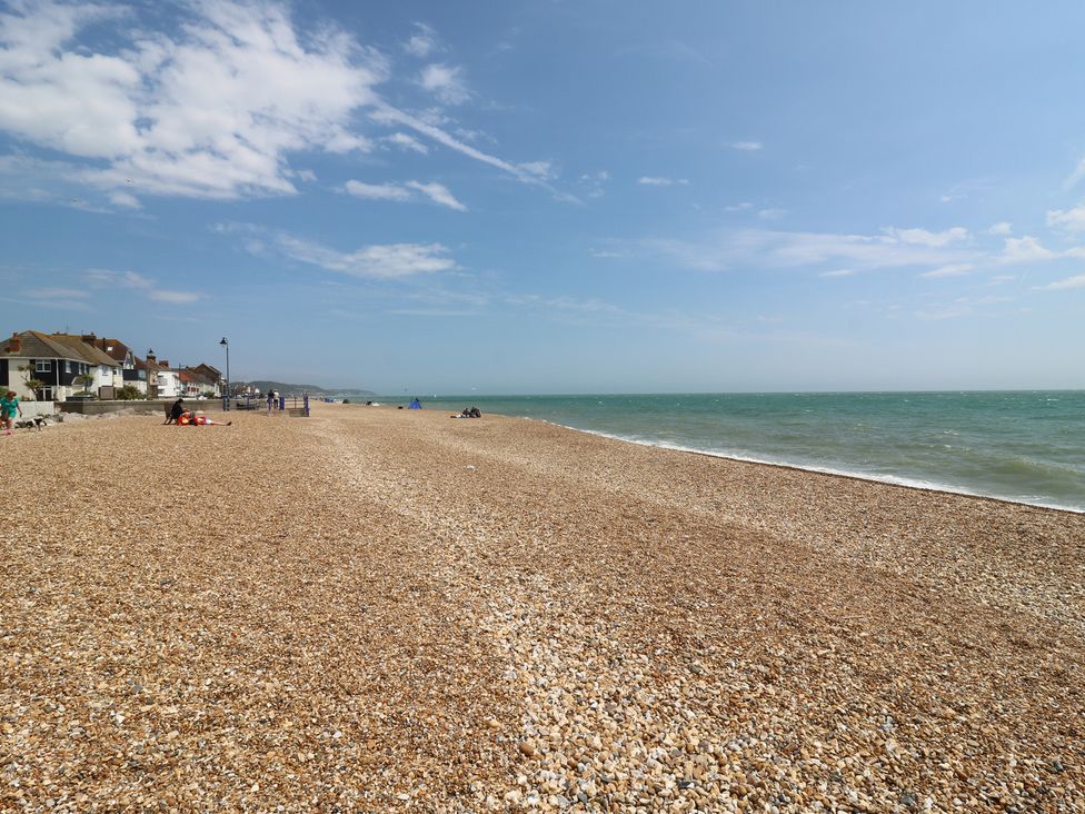 A beach with pebbles and people at Flat 4 Hythe