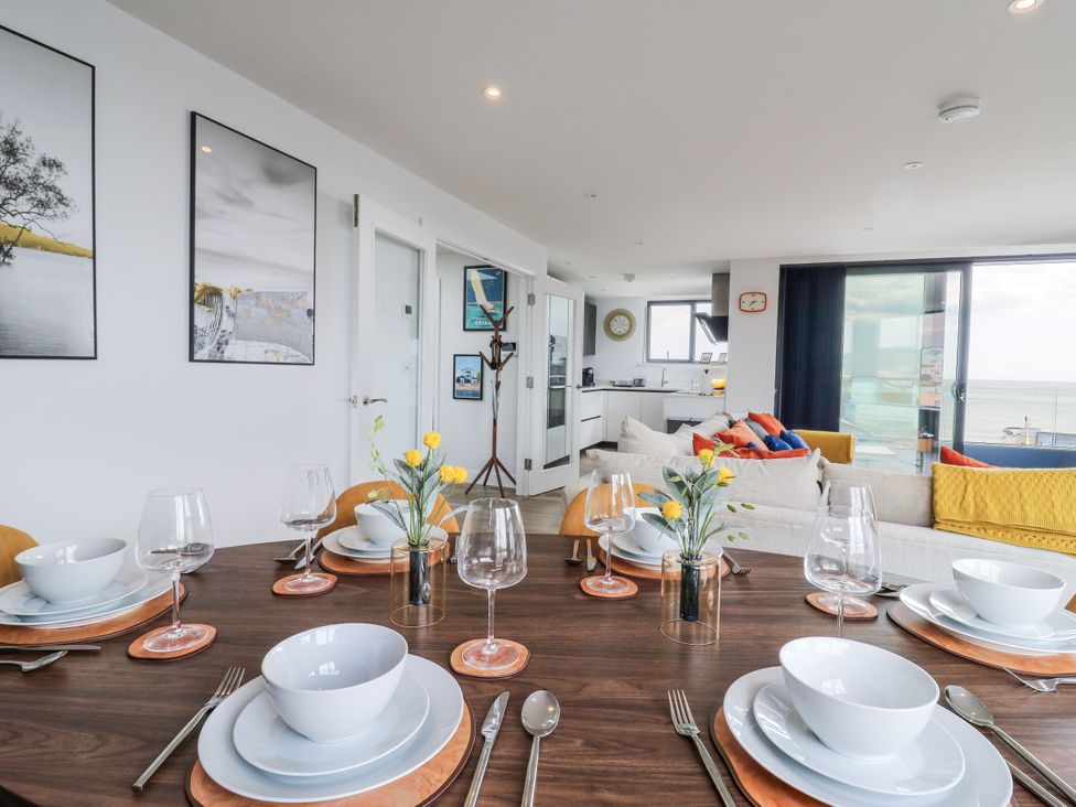 A dining room with a table set for a meal at Flat 4 Hythe