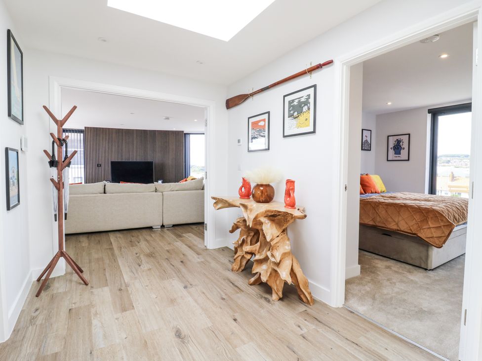 A hallway with a coat rack and wooden table at Flat 4 Hythe