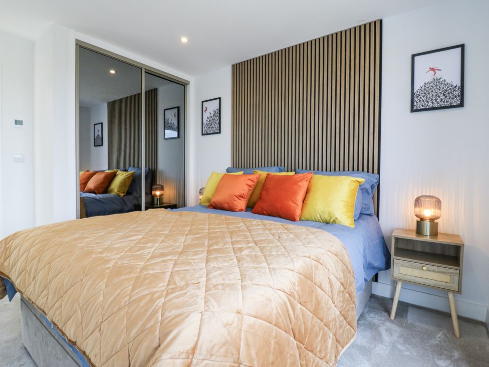 A bedroom with a bed and nightstand at Flat 4 Hythe
