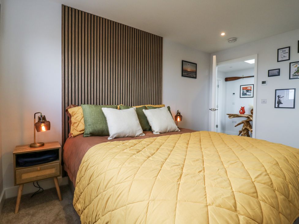 A bedroom with a bed and wooden wall features at Flat 4 in Hythe