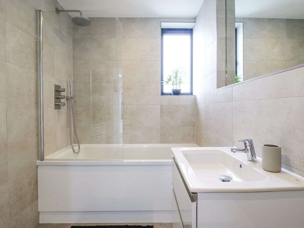 A bathroom with a bathtub and sink at Flat 4 Hythe