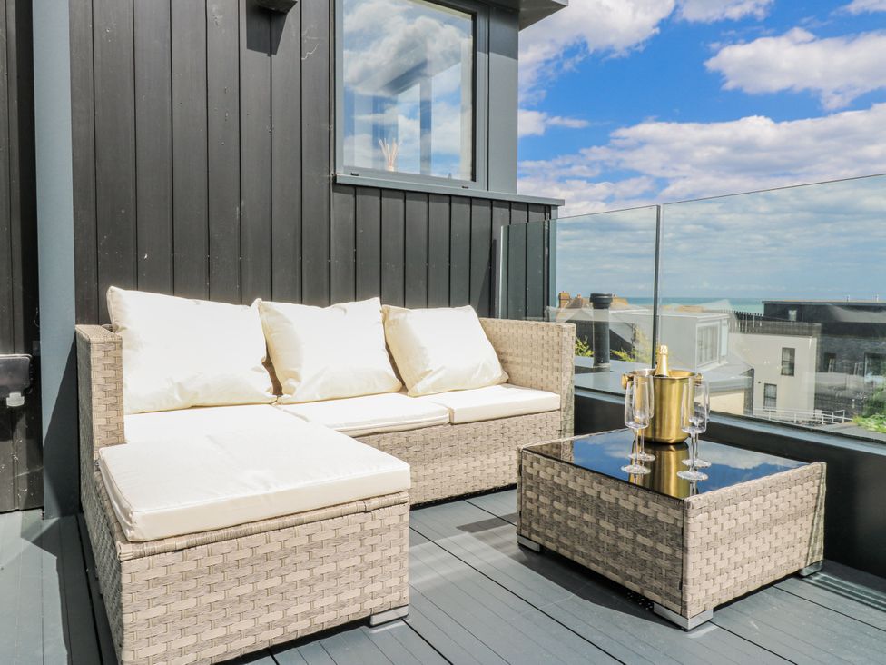 A balcony with a sofa and table at Flat 4 in Hythe