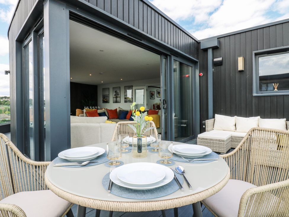 An outdoor dining area with a round table and chairs at Flat 4 Hythe