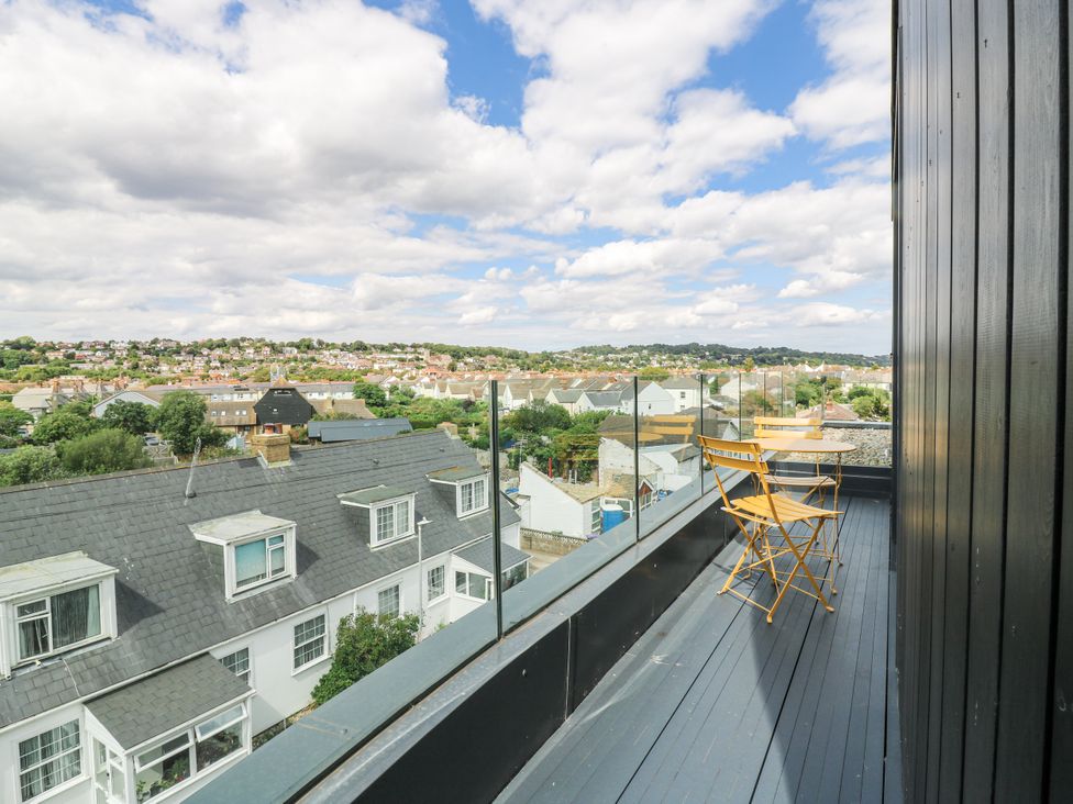 A balcony with chairs and a table overlooking a view at Flat 4 Hythe