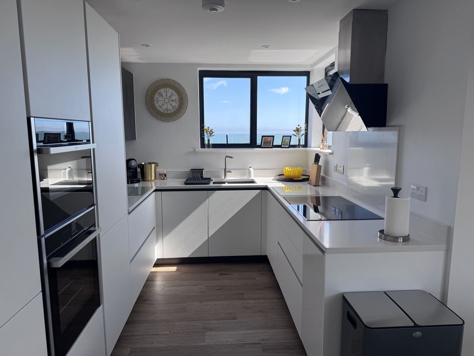 A kitchen with appliances and a window view at Flat 4 in Hythe