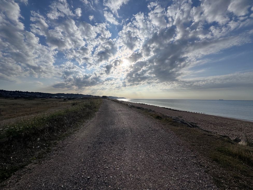 A beach path beside the ocean under a cloudy sky at Flat 4 Hythe