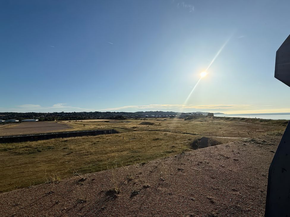 A coastal view with grassland and distant buildings at Flat 4 Hythe