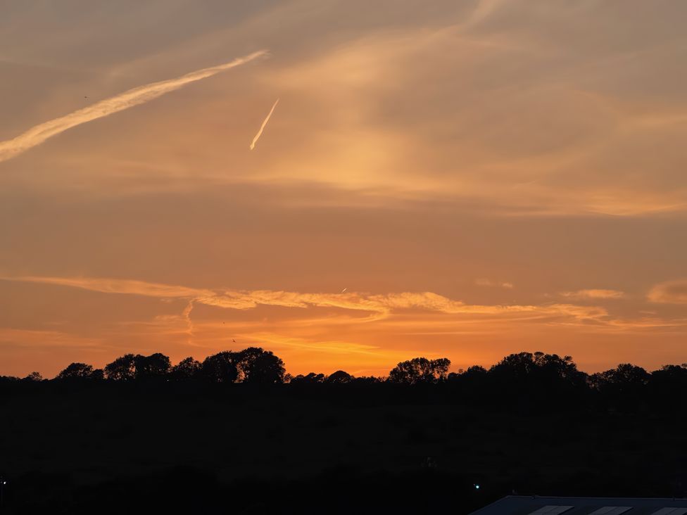 A sunset with clouds and trees silhouetted at Flat 4 in Hythe
