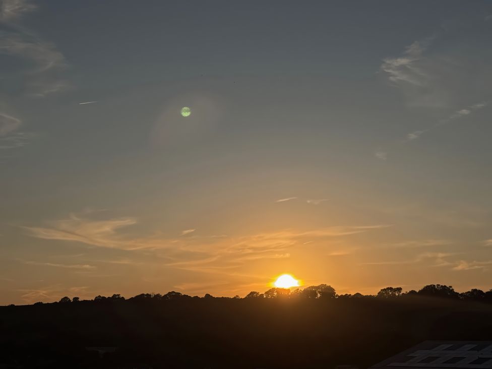 A sunset view with clouds and trees at Flat 4 in Hythe