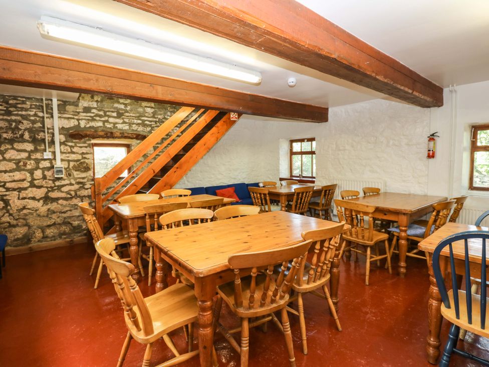 A dining room with wooden tables and chairs at West Barn